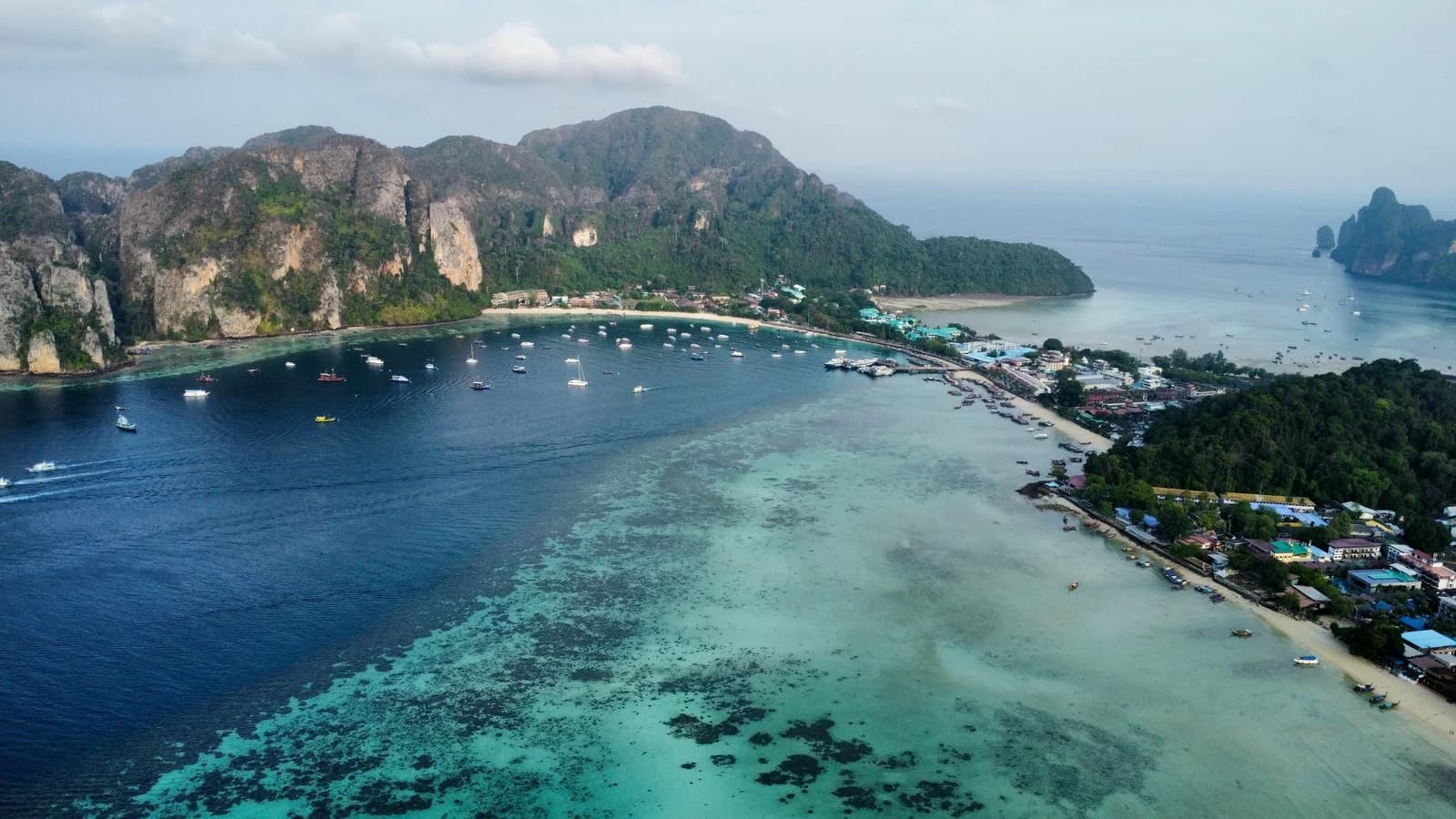 Aerial view of the Phi Phi Islands coastline in Thailand — crystal-clear turquoise waters around limestone cliffs